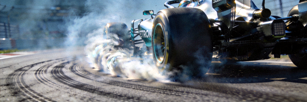 F1赛车在赛道上飞驰，轮胎与地面摩擦产生烟雾
